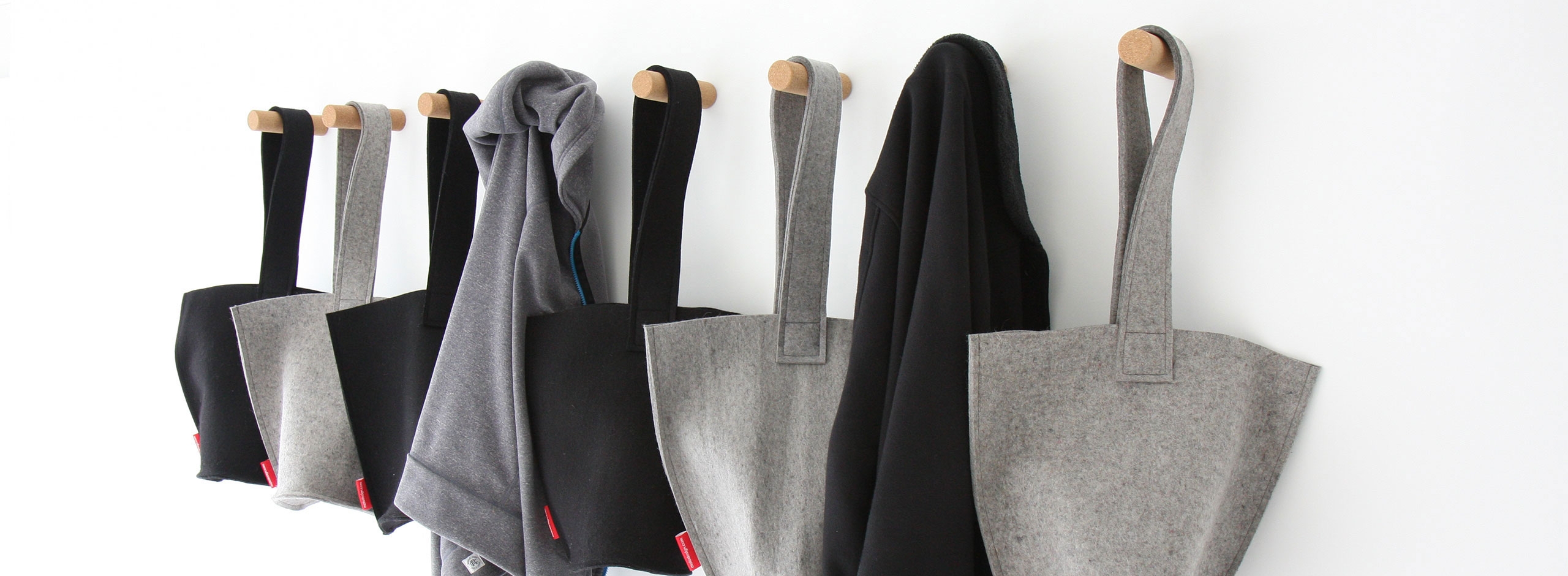 sweaters and hobo bag hangs from cork peg