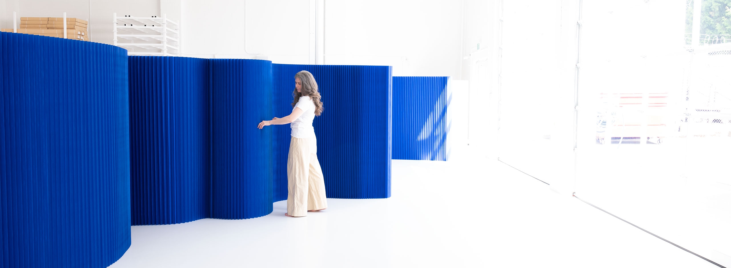 This blue wall is a a flexible room divider made from paper. As a dramatic backdrop for special events or daily life these movable partitions can be made into any shape and easily flat pack for storage and portability.