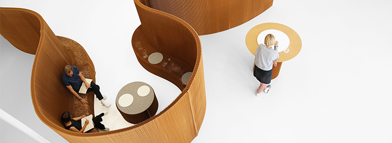 Benchwall expanding paper bench that is also a an acoustic space partition. The flexible shape can change from a meeting room to more open seating area