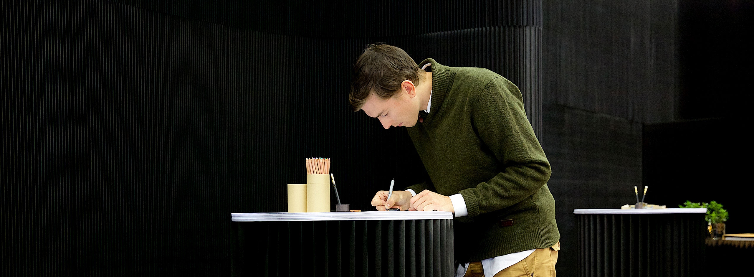 man draws on a sketching circle in front of a black thinwall