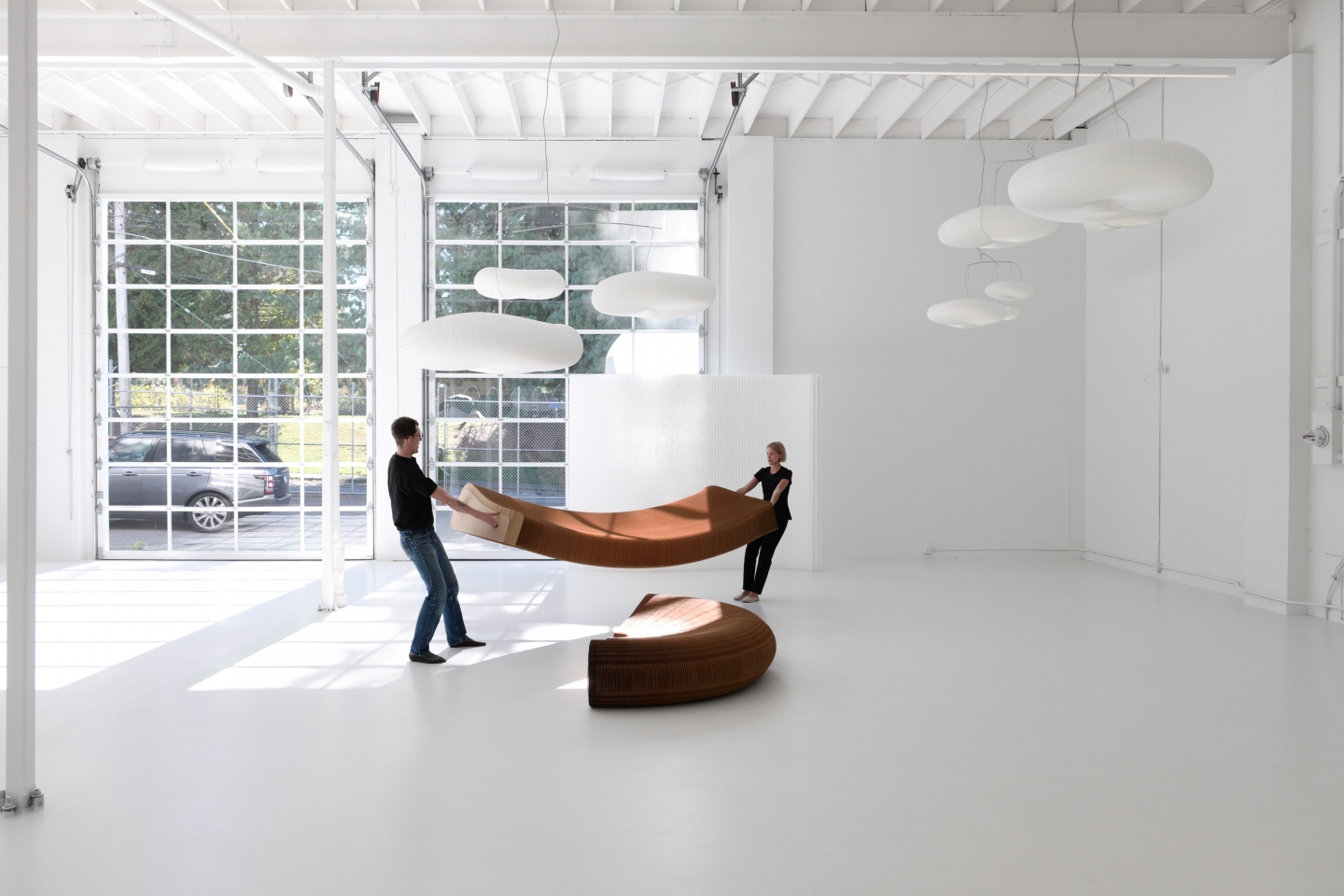 two people stretch open a third of the base for softseating lounger