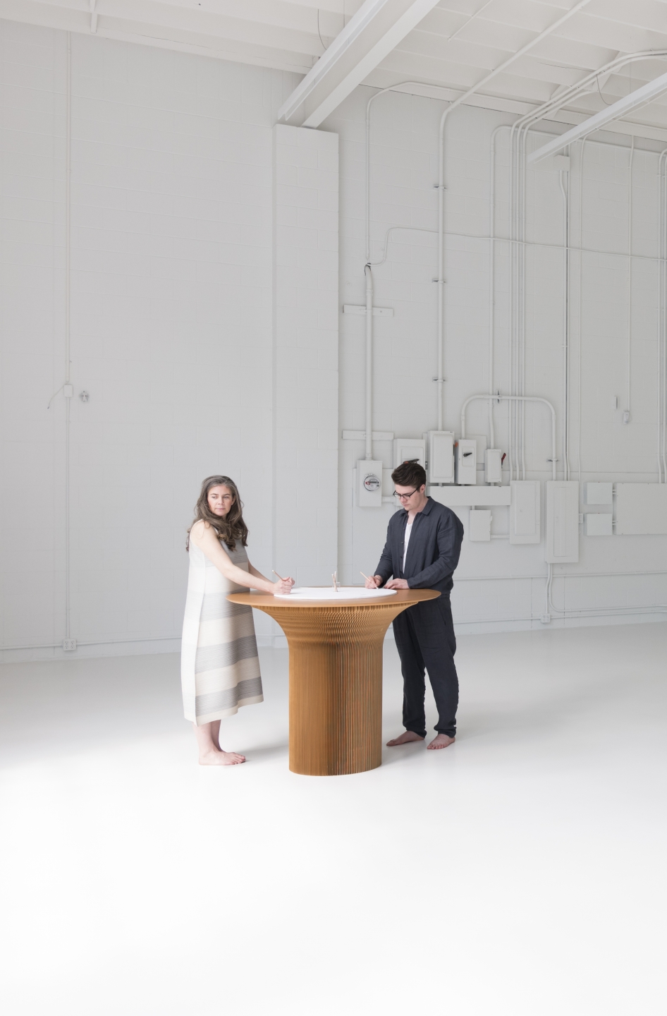 two people stand at a round top cantilever table