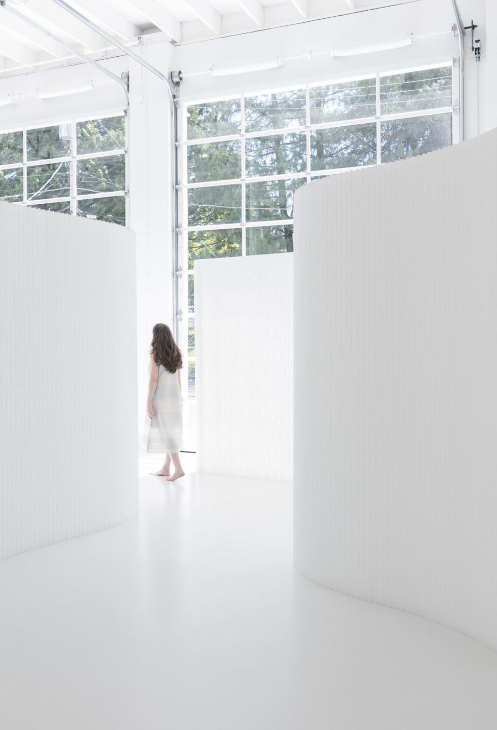 a woman drifts through an installation of textile softwall - moveable wall partitions by molo