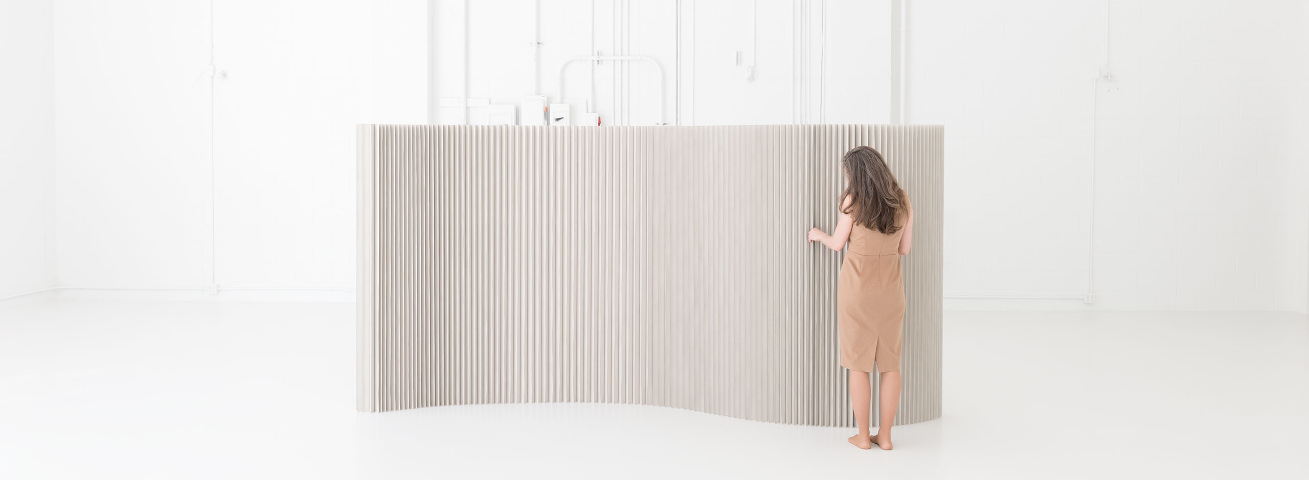 a woman arranges a custom colour softwall