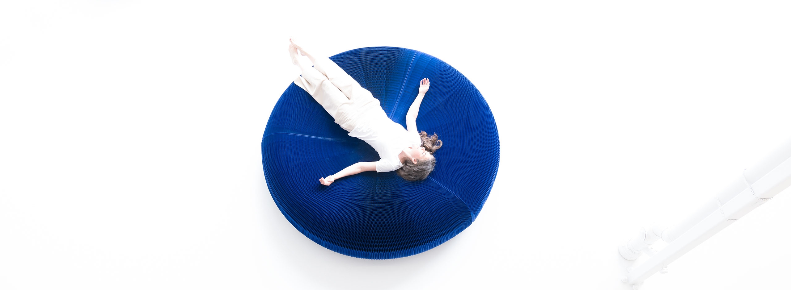 overhead view of a woman laying on an indigo paper lounger