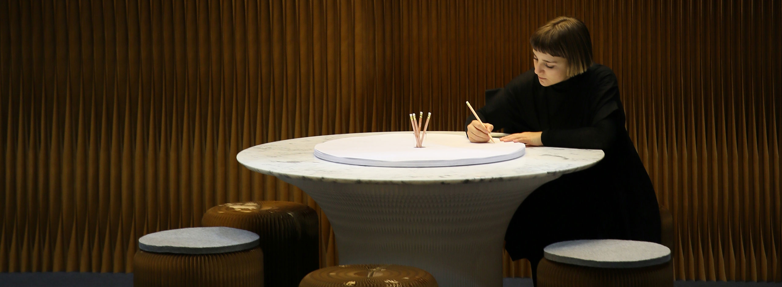 woman draws on the sketching circles accessory for cantilever table