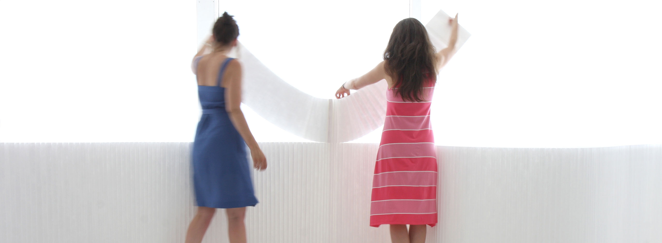 two women arrange white textile softblocks