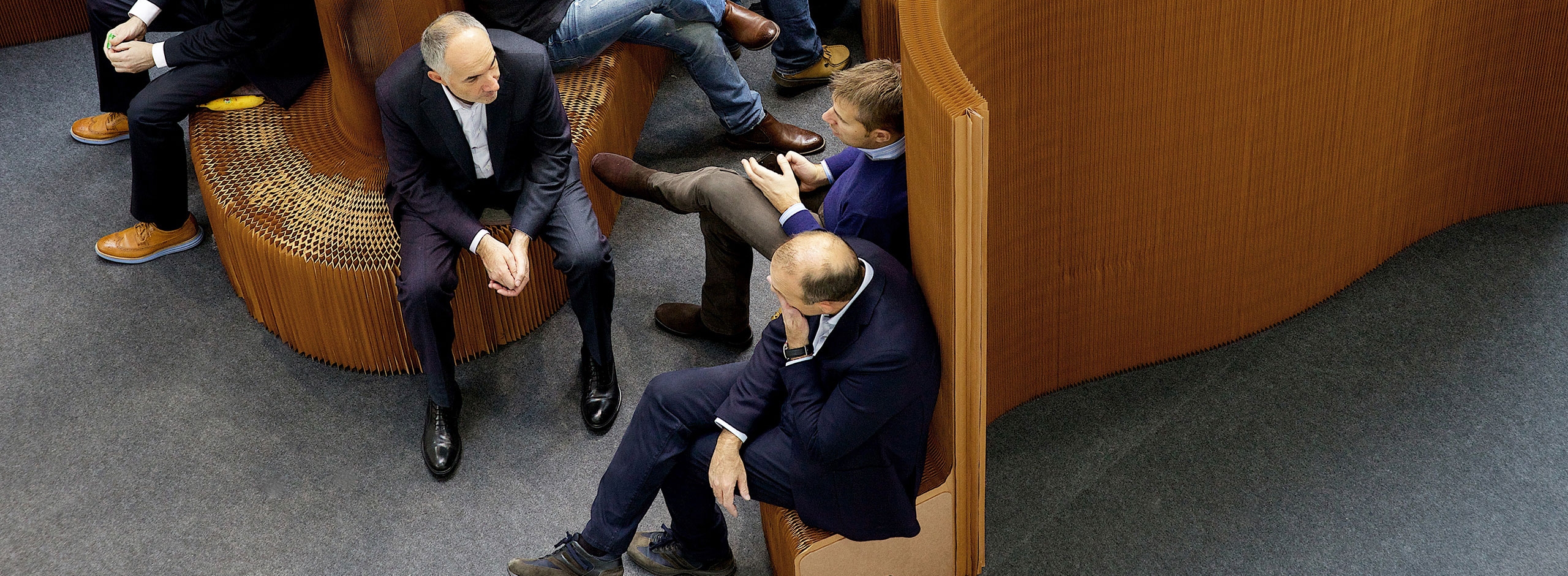 at Orgatec 2014, a small crowd of businessmen sit on an installation of benchwalls