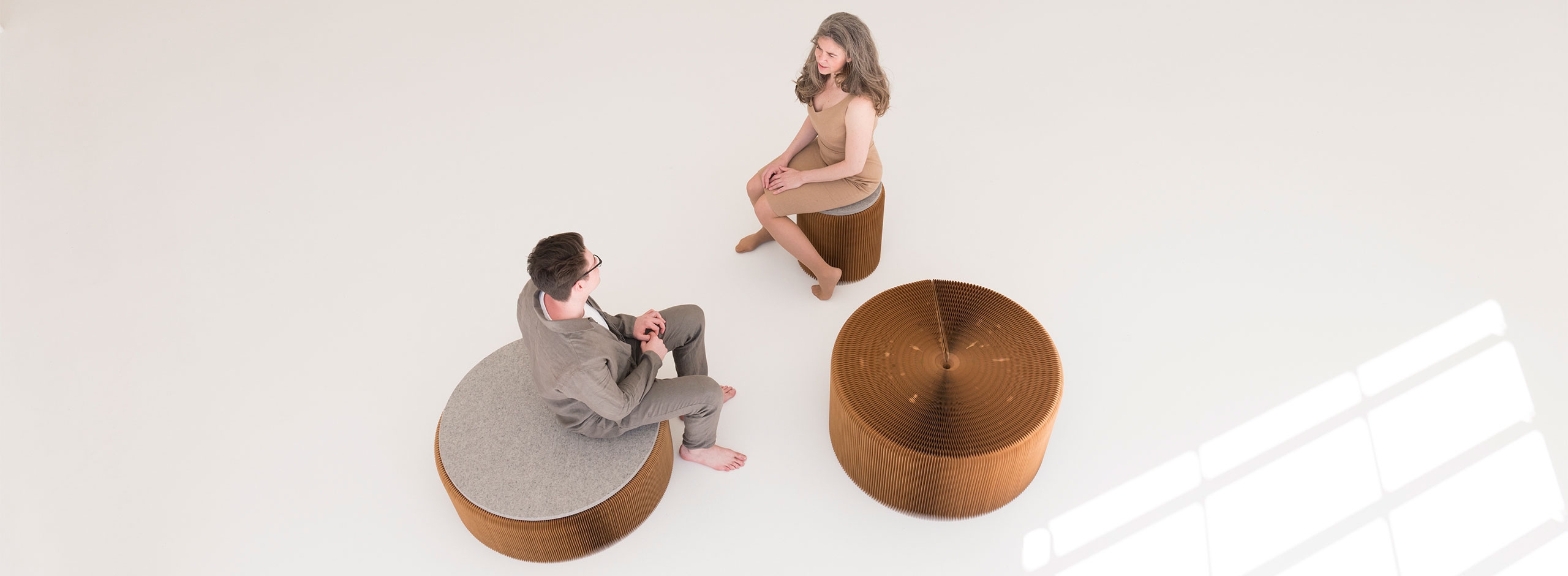 two people sit on softseating fanning stool + bench