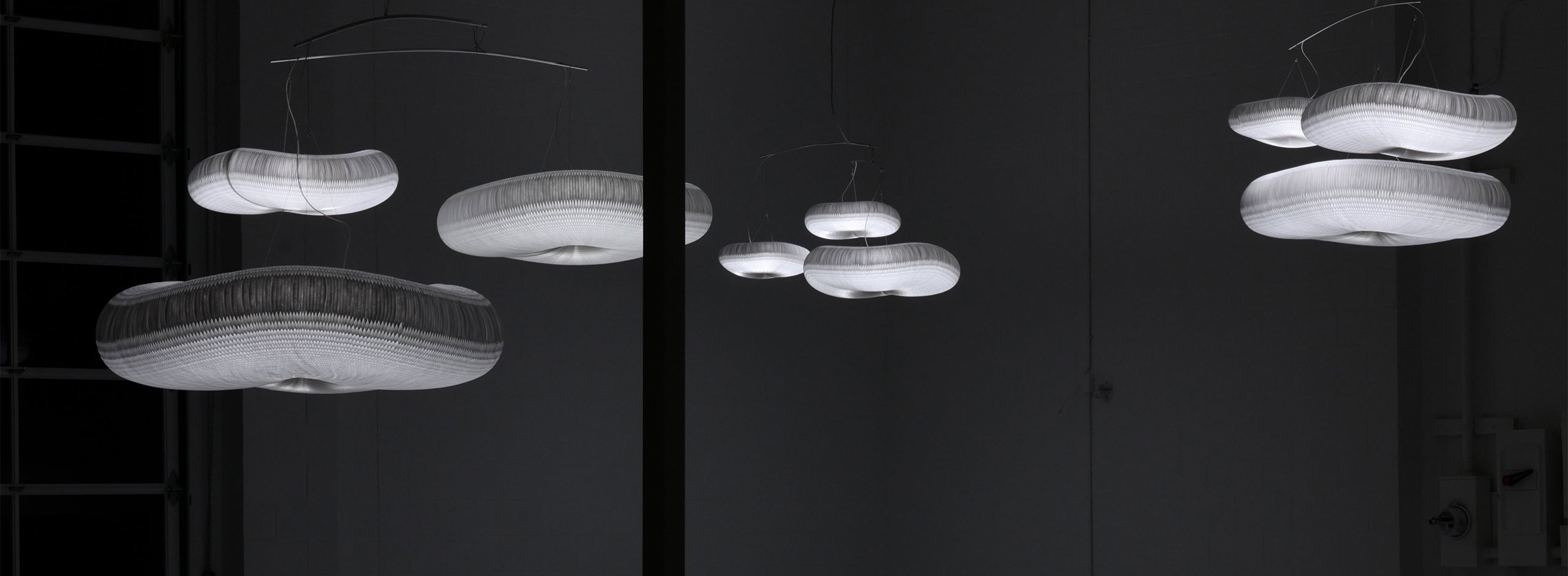 three cloud mobiles hang in the dark