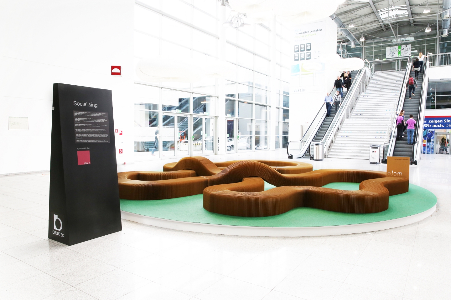 paper bench / furniture by molo - a serpentine bench made from softseating set up in the central foyer of Orgatec